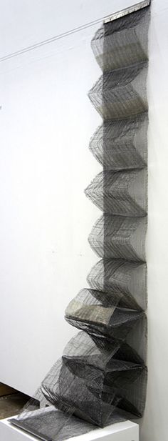 there is a very tall stack of mesh on the wall