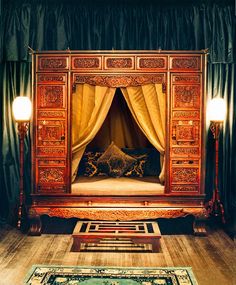 an ornate wooden bed frame with curtains on it