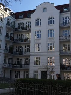 a tall white building with balconies and windows