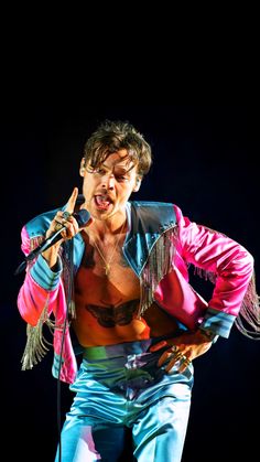 a man in colorful clothes holding a microphone