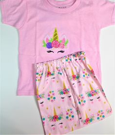 Cute little short set for a little girl who loves unicorns    This pair of shorts is cotton fabric with unicorn print on pink, the shirt is appliqued with the same print.  Comfortable elastic waistband in shorts make it comfortable to wear, and the tee shirt is soft and pink.   Available in 2-6 sizes Happy Unicorn, Unicorn Tee, Unicorn Face, Pillowcase Dress, Unicorn Print, Tee Shirt Dress, Pink Tee, Girls Clothing Sets, Little Dresses