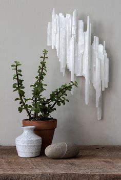 a potted plant sitting on top of a wooden table next to a white sculpture