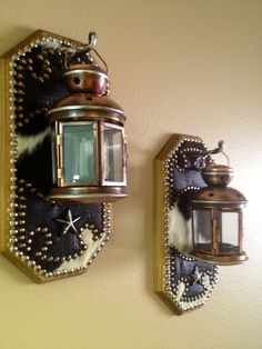 two wall mounted lights on the side of a wall next to a mirror and light fixture