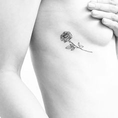 a rose tattoo on the side of a woman's right rib - up breast