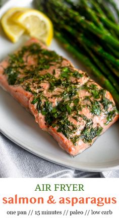 salmon and asparagus on a plate with lemon wedges for garnish