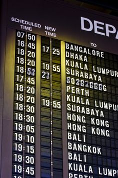 an airport departure board showing the time and times for all flights in malaysia stock photos