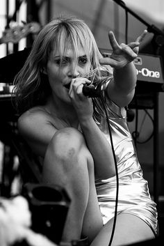 a woman sitting in front of a microphone on stage