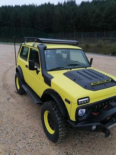 a yellow truck parked on top of a gravel field