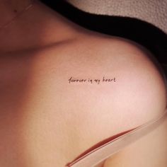 a woman's chest with the words forever in my heart tattooed on her left side