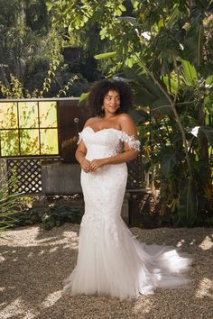 a woman in a white wedding dress posing for a photo with her hands on her hips