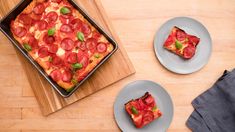 two plates with slices of pepperoni pizza on them next to a cutting board and oven mitts