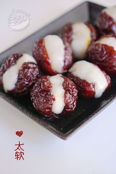 dates with white icing on a black plate