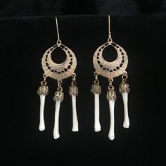 Real muskrat foot bones are 1 inch and are held by antiqued brass caps. They hang from .75 inch, Victorian style, etched brass components. The earrings are dangling from contemporary gold filled French hook earrings. The earrings as a whole measure 2.75 inches. They are very light weight and comfortable. The vintage, circa 1960, etched brass hoops and brass caps are from old stock , never used. They have contemporary bones added to them. The detail in the cast earrings include open work design a Unique Bone-colored Nickel-free Earrings, Bohemian Bone-colored Nickel-free Earrings, Unique Bone-colored Brass Jewelry, Unique Brass Jewelry In Bone Color, Handmade Metal Jewelry In Bone Color, Bohemian Bone-colored Pierced Earrings, Bone Color Dangle Earrings With Ear Wire, Bohemian Bone-colored Earrings, Nickel-free Bone Dangle Earrings