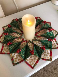 a candle sits in the center of a christmas wreath