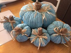 blue pumpkins with twine wrapped around them on a table