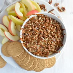 a white plate topped with crackers and apples