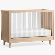 a wooden crib with a white sheet in the bottom half and two legs on each side