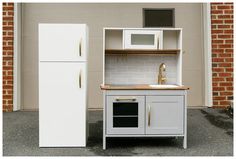 a white refrigerator freezer sitting next to a wooden counter top with a microwave oven on it