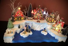 a christmas village with houses and trees on an ice floet