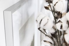 cotton flowers in front of a mirror with white paint on the frame and glass door