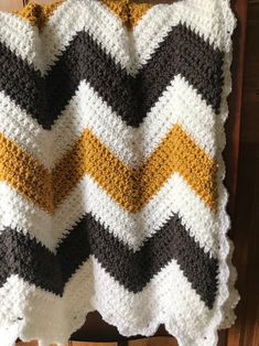 a crocheted blanket sitting on top of a wooden chair