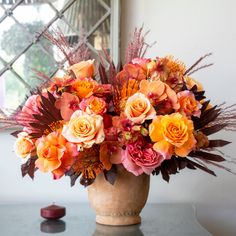 a vase filled with lots of different colored flowers