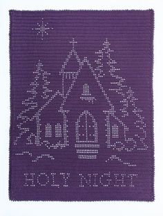 a purple crocheted rug with a house and trees on it