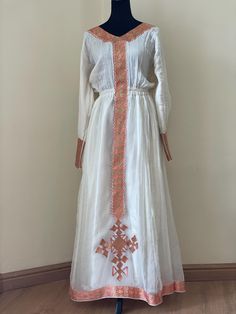 Beautiful habesha kemis with a intricate design trim. The dress is a hand made and machine embroidered.  *The dress is made to order, please include your size when you place your order.  *Please include your phone number with your address. It's required on the shipping form. Traditional White Maxi Dress With Intricate Embroidery, Traditional Tunic Dress With Embroidered Border, Traditional Ceremonial Fitted Embroidered Dress, Traditional Fitted Ceremonial Embroidered Dress, Fitted Traditional Embroidered Dress For Ceremonial Occasions, White Chikankari Embroidery Dress For Traditional Ceremonies, White Dress With Chikankari Embroidery For Traditional Ceremonies, Ceremonial Dresses With Embroidered Border For Festivals, Festival Tunic Dress With Embroidered Border