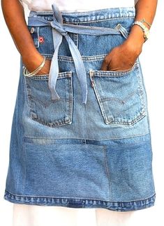 a woman wearing a denim skirt and white t - shirt with her hands in her pockets