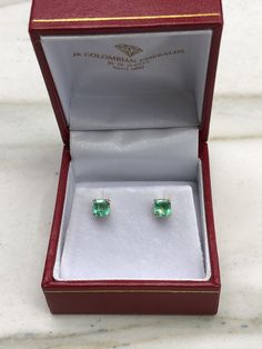 Featured here is a beautiful set of Asscher cut Colombian emerald studs in fine 14K yellow gold. Displayed are vibrant-green emeralds with very good transparency, accented by a simple double-prong yellow gold mount, allowing for the emerald to be shown in full view. Minor flaws such as a carbon spec are seen in one emerald. The earth mined, green Colombian emeralds have a desirable lush green color with excellent qualities. These earrings are ideal for everyday use and are the perfect accessory Emerald Cut Green Diamond Earrings, Emerald Round Cut Fine Jewelry Earrings, Fine Jewelry Emerald Round Cut Earrings, Green Diamond Round Cut Earrings, Emerald Round Cut Earrings Fine Jewelry, Green Diamond Earrings With Prong Setting, Emerald Round Cut Fine Earrings, Emerald Round Cut Earrings For Anniversary, Round Cut Emerald Earrings For Anniversary