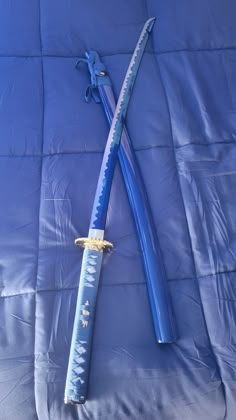 two blue swords laying on top of a blanket