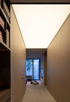 an empty hallway leading to a living room with bookshelves on either side and a couch in the middle