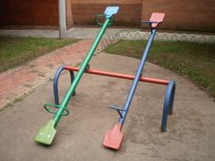 an empty playground with swings and bars in front of a brick building