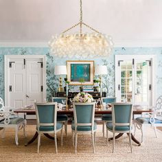 a dining room with blue chairs and a chandelier