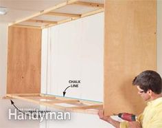 a man working on cabinets in the kitchen