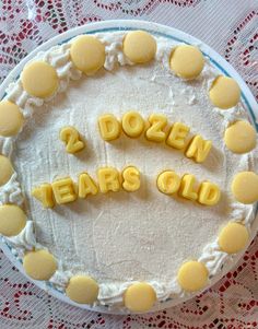 a cake with the words dozen ears old spelled out in yellow icing on top