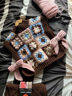 a crocheted blanket and some yarn on a bed