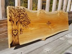 a wooden sign with a tree and hearts on it