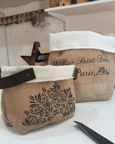 two burlap bags sitting on top of a table next to scissors and other items