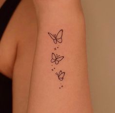 a woman's arm with three butterfly tattoos on the left side of her arm