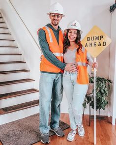 a man and woman standing in front of a bump ahead sign