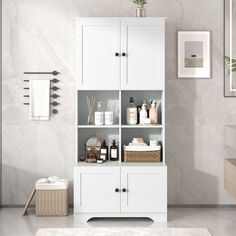 a bathroom with white cabinets and towels on the shelves