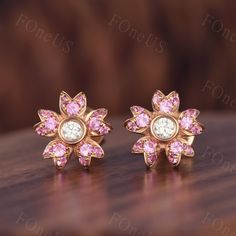 These flower style pink sapphire earrings shine with luminous elegance. They are sophisticated and chic. These tiny gold and gemstone earrings will be perfect addition to your stunning look and will make your beauty shine! Details Gemstone: Natural Pink Sapphire Middle stone: 2.5mm round cut Moissanite Each set comes with 2 post back earrings ◇◇Processing time◇◇ Any item on my store is handmade,made to order,no stock. Typically,it takes 2-3 weeks to complete the item. ◇◇Delivery time◇◇ --Domesti Wedding Pink Sapphire Earrings, Pink Diamond Earrings With Prong Setting For Wedding, Rose Gold Pink Sapphire Earrings As Gift, Rose Gold Pink Sapphire Earrings For Gift, Pink Earrings With Halo Design Fine Jewelry, Fine Jewelry Pink Earrings With Halo Design, Pink Sapphire Earrings For Wedding, Pink Halo Earrings Fine Jewelry, Pink Halo Design Fine Jewelry Earrings