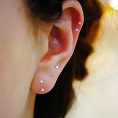 a close up of a person's ear with stars on it