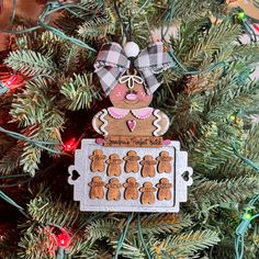 a christmas ornament hanging from the top of a tree with gingerbreads on it