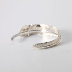 "The silver feather bangle is a part of our extensive collection of silver feather jewelry. A single silver feather, curves gracefully to form the bracelet. Inspired by the Native American culture, the design features the rising plumes of the eagle. These feathers help the bird to gain height when flying, and soar up to the heavens. The eagle, and its feathers, have a special meaning in the Native tradition - they are a symbol of wisdom, courage and honor. This is the spirit the silver feather b Adjustable Nature-inspired Cuff Bangle Bracelet, Adjustable Silver Nature-inspired Cuff Bracelet, Nature-inspired Adjustable Silver Cuff Bracelet, Feather Cuff Bracelet, Feather Cuff, Eagle Feather, Boho Bangle, Eagle Feathers, Feather Bracelet