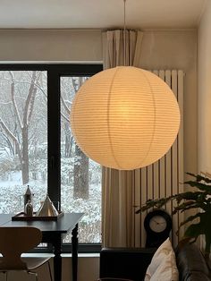 a living room filled with furniture and a large window covered in frosty white paper lanterns