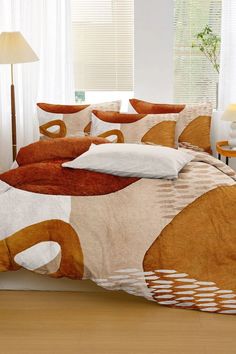 a bed with orange and white comforters in a room