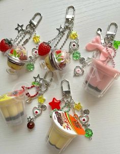 several different key chains with various items attached to them on top of a white table