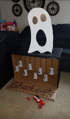 there is a cardboard ghost in the middle of a box with many bells on it